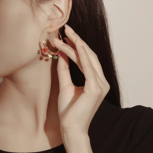 Close-up of bohemian gold hoop earrings with colorful turquoise beads on a female model