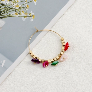 Detail of bohemian gold hoop earrings with colorful turquoise stones and beads