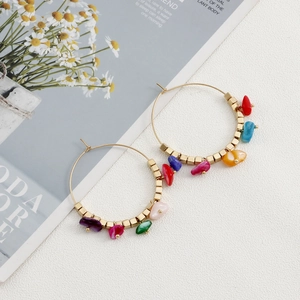 Detail of bohemian gold hoop earrings with colorful turquoise stones and square beads