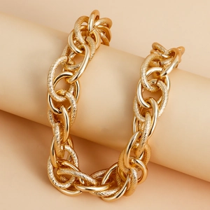Detail of chunky gold chain necklace with alternating smooth and textured links