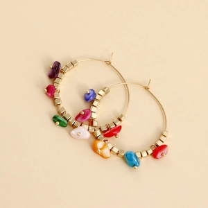 Detail of bohemian gold hoop earrings with colorful turquoise and seashell stone charms