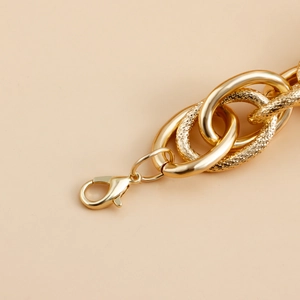 Detail of gold chunky chain necklace with polished and textured links and lobster clasp