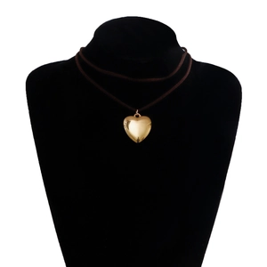 Detalle del colgante corazón dorado 3D en cordón de terciopelo marrón ajustable