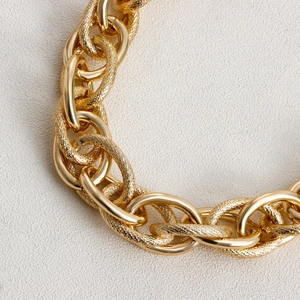 Detail of chunky gold chain necklace with alternating polished and hammered oval links