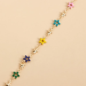 Detail of gold waist chain with colorful star pendants and hollow star charms