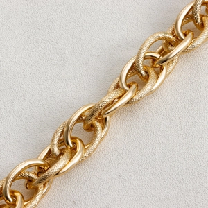 Detailed close-up of chunky gold aluminum link chain with mixed polished and hammered textures