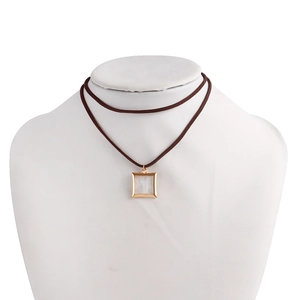 Detalle de colgante cuadrado de concha blanca en cordón marrón con marco dorado elegante
