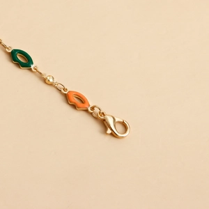 Detail of gold waist chain featuring green and orange enamel lips and lobster clasp closure