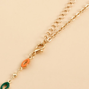 Detailed close-up of gold chain lobster clasp and colorful enamel lip pendants