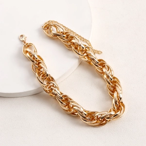 Close-up of golden geometric aluminum chain necklace showing thick links and lobster clasp