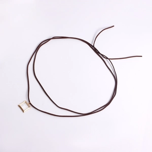 Detalle del colgante cuadrado dorado con incrustación de nácar en collar de cordón