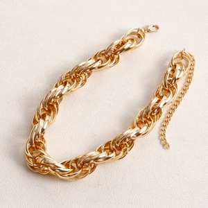 Detailed close-up of heavy gold interlocking link chain with lobster clasp and extender