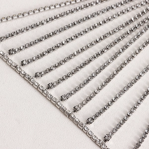 Macro close-up of sparkling multi-row rhinestone fringe tassels on silver metal body chain