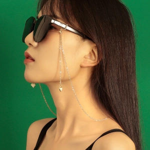 Goldene Brillenlkette aus Metall mit weißen Herzanhängern an einer Sonnenbrille für Damen
