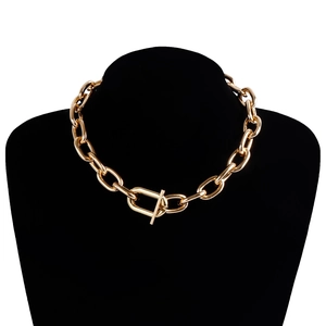 Close-up of bold golden chunky chain necklace with OT toggle clasp on a neck model