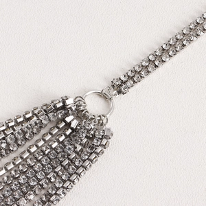 Detailed close-up of multi-layer silver rhinestone tassels with crystal link fringe
