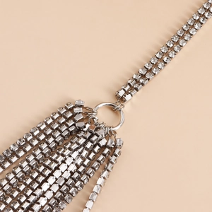 Detailed close-up of a sparkling silver rhinestone body chain with elegant fringe design