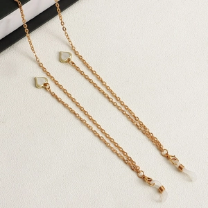 Detailansicht der goldenen Brillenkette mit weißen Herzanhängern und Schlaufen