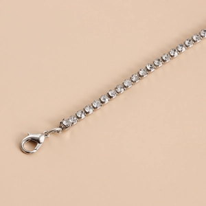 Macro detail of silver-tone tennis chain with sparkling rhinestones and lobster clasp