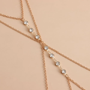 Detailed close-up of golden multi-layer body chain with sparkling crystal rhinestones