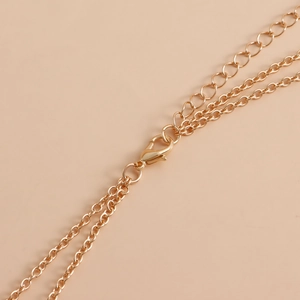 Detail view of gold bikini body chain showing lobster clasp and adjustable extension links