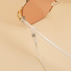 Detail of silver eyewear chain with lobster clasp and silicone loop on orange sunglasses