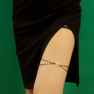Sexy elastic leg chain featuring black beads and a golden flower charm pendant