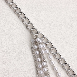 Close-up of layered silver chain with white imitation pearl tassels for body jewelry
