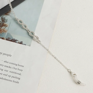 Detail of silver eyewear chain with infinity symbols encrusted in rhinestones and rubber loops