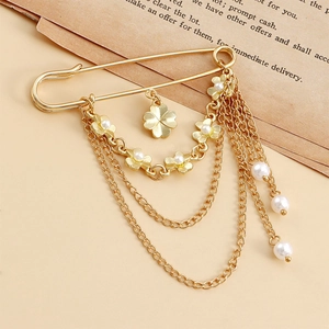 Détail macro de la broche à chaînes dorées avec perles et pendentif trèfle élégant