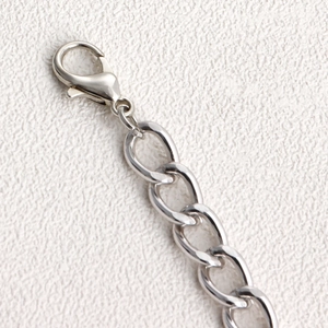 Close-up of silver multilayer chain with lobster clasp and flat oval metal links