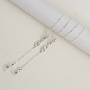 Close-up of silver glasses chain with diamond-encrusted infinity symbols and rubber loops