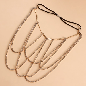Detail of sexy golden leg chain with layered rhinestones and black elastic band