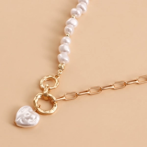 Detail showing the mixed pearl and gold link chain texture with a heart pearl pendant