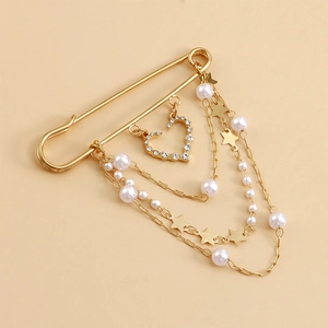Détail de la broche épingle dorée avec trois chaînes et pendentifs cœur et perles