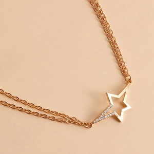 Close-up of double-layer gold chain featuring a hollow star pendant with zircon stones