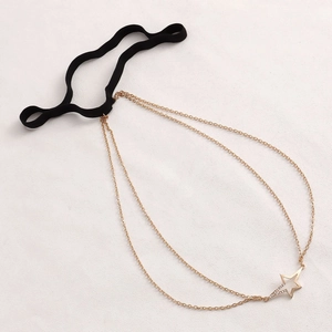 Detail of black elastic leg chain with double gold layers and rhinestone star pendant