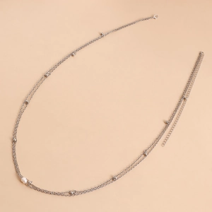 Detail of silver double-layer waist chain featuring white pearl and metal beads with lobster clasp