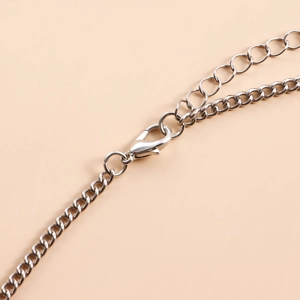 Detailed close-up of a silver leg chain with lobster clasp and adjustable extension chain