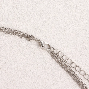 Detail view of silver metal waist chain with lobster clasp and adjustable extender link