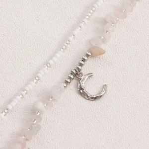 Macro detail of Bohemian double-layered beaded chain with crescent moon and pink stones