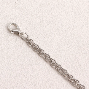 Close-up of silver metal waist chain showing the lobster clasp and double-layered links