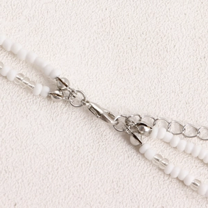 Detail of silver lobster clasp and extension chain on white bohemian beaded waist chain