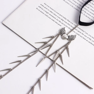 Detailed view of Gothic winged heart necklace with silver chains and metallic spikes
