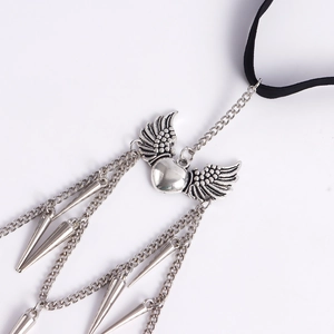 Detail of gothic leg chain with silver winged heart and dangling metal spikes