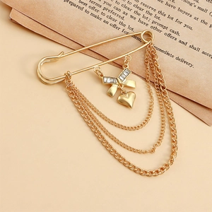 Broche épingle dorée avec chaînes multicouches, nœud en strass et pendentif cœur