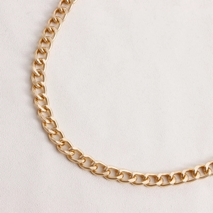 Detail of chunky gold Cuban link chain with polished finish and thick oval metal rings