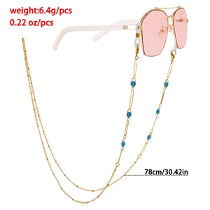 Detail of evil eye eyewear chain in gold finish with blue beads, 78cm length