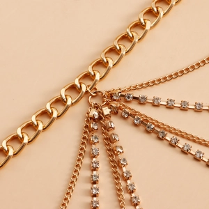 Détail d'une chaîne de taille dorée multicouche avec maillons et accents de strass