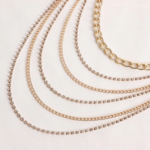 Detail of multi-layer gold metal body chain with shimmering rhinestones and layered texture